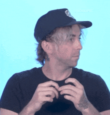 a man wearing a hat and a black shirt with the words billboard on the bottom