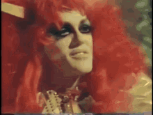 a close up of a person 's face with a red wig