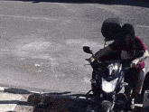 a woman in a red shirt is sitting on a black motorcycle
