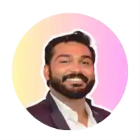 a man with a beard is smiling in front of a pink circle