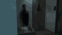 a woman is walking down a hallway next to a man in a tank top .