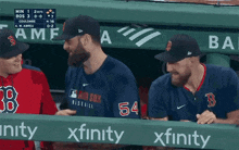 a group of red sox players are sitting in a dugout