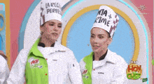 two women wearing chef hats are standing next to each other .