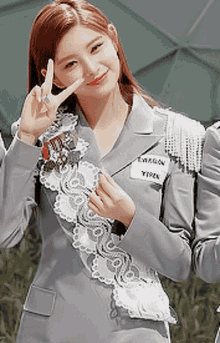 a woman wearing a gray jacket with a name tag that says twagon