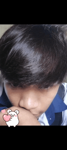 a close up of a young boy 's face with a sticker of a hamster holding a heart