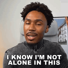 a man in a striped sweater says " i know i 'm not alone in this "