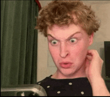 a man with curly hair is making a funny face