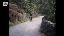 a man riding a bike down a road with the letters s4c on the bottom right