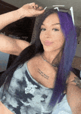 a woman with purple hair has a tattoo on her chest that says " juice the pirate "
