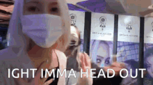 a woman wearing a mask is standing in front of a wall with signs that say ' dreamcatcher ' on them