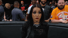 a woman stands in front of a crowd with a man wearing an orange shirt that says ' united kingdom wrestling '