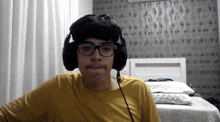 a young boy wearing headphones and glasses looks at the camera