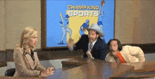 a man in a cowboy hat talks to a woman in front of a screen that says " champ kind sports "