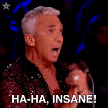 a man sitting in front of a microphone with the words ha-ha insane written below him