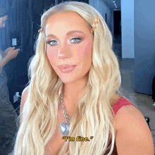 a woman with blonde hair is wearing a necklace that says " i 'm fine " on it