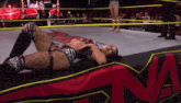 a female wrestler is laying on the ground in a ring with anthem written on the side