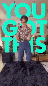a man is dancing in front of a green sign that says you got this