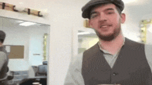 a man wearing a hat and vest is standing in a room