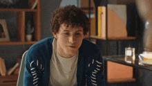 a young man wearing a blue sweater that says ' disrupted ' on it
