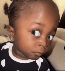 a close up of a baby making a funny face with her eyes closed .