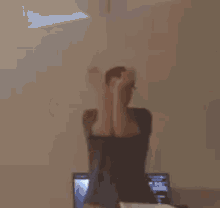 a man is standing in front of a computer in a dark room .