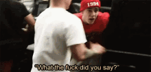 a man wearing a 1994 hat is talking to another man