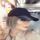 a mannequin wearing a black baseball cap and a tan coat
