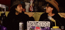 a man and a woman are sitting in front of a laptop that says capslock ts2