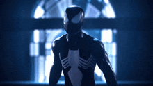 a man in a black spiderman suit stands in a dark room