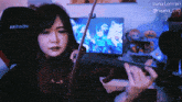 a woman playing a violin in front of a screen that says luna lorrain