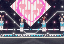 a group of anime characters are standing on a stage with a heart in the background