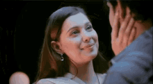 a man and a woman are looking at each other and smiling .