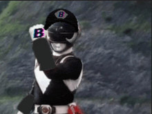 a black and white power ranger with the letter b on his helmet