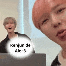 a man with pink hair is sitting in front of a laptop with a speech bubble that says renjun de ale 3