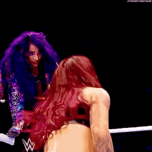two women with red hair are wrestling in a ring .