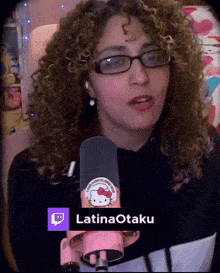 a woman with curly hair is wearing glasses and holding a pink hello kitty microphone with the name latinaotaku on the bottom
