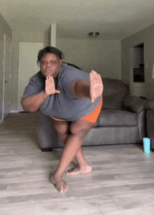 a woman is standing on one leg in a living room