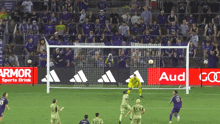 a soccer game is being played in front of a armor sports drink ad