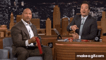 a man in a suit sits next to a man in a tie on a make a gif.com page