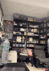a bottle of sprite sits on a table in front of a bookshelf full of books