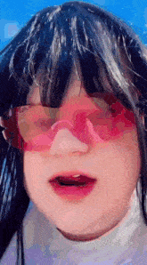 a close up of a person wearing pink sunglasses .