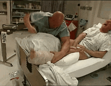 a man in a hospital bed with a wrestler logo on the wall