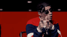 a man wearing sunglasses and a bandana is pointing