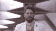 a man with a beard is wearing a lab coat and tie .