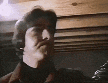 a man wearing headphones is making a funny face in a dark room .