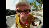 a man wearing glasses and a wig points at the camera