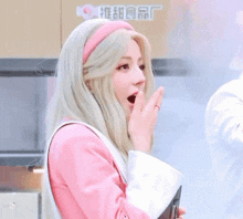 a woman with blonde hair and a pink headband is wearing a pink jacket and a pink headband .