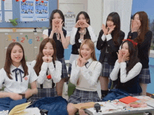 a group of girls are posing for a picture in front of a bulletin board with the numbers 3 and 12 on it