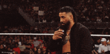 a man in a wrestling ring talking into a microphone with the caption " are you okay "