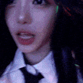 a close up of a woman wearing a tie and ear buds .